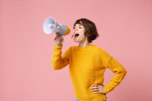 Funny young brunette woman girl in yellow sweater posing isolated on pastel pink wall background studio portrait. 