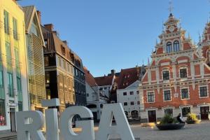 Image of historic public square with large letters spelling RIGA place in foreground.